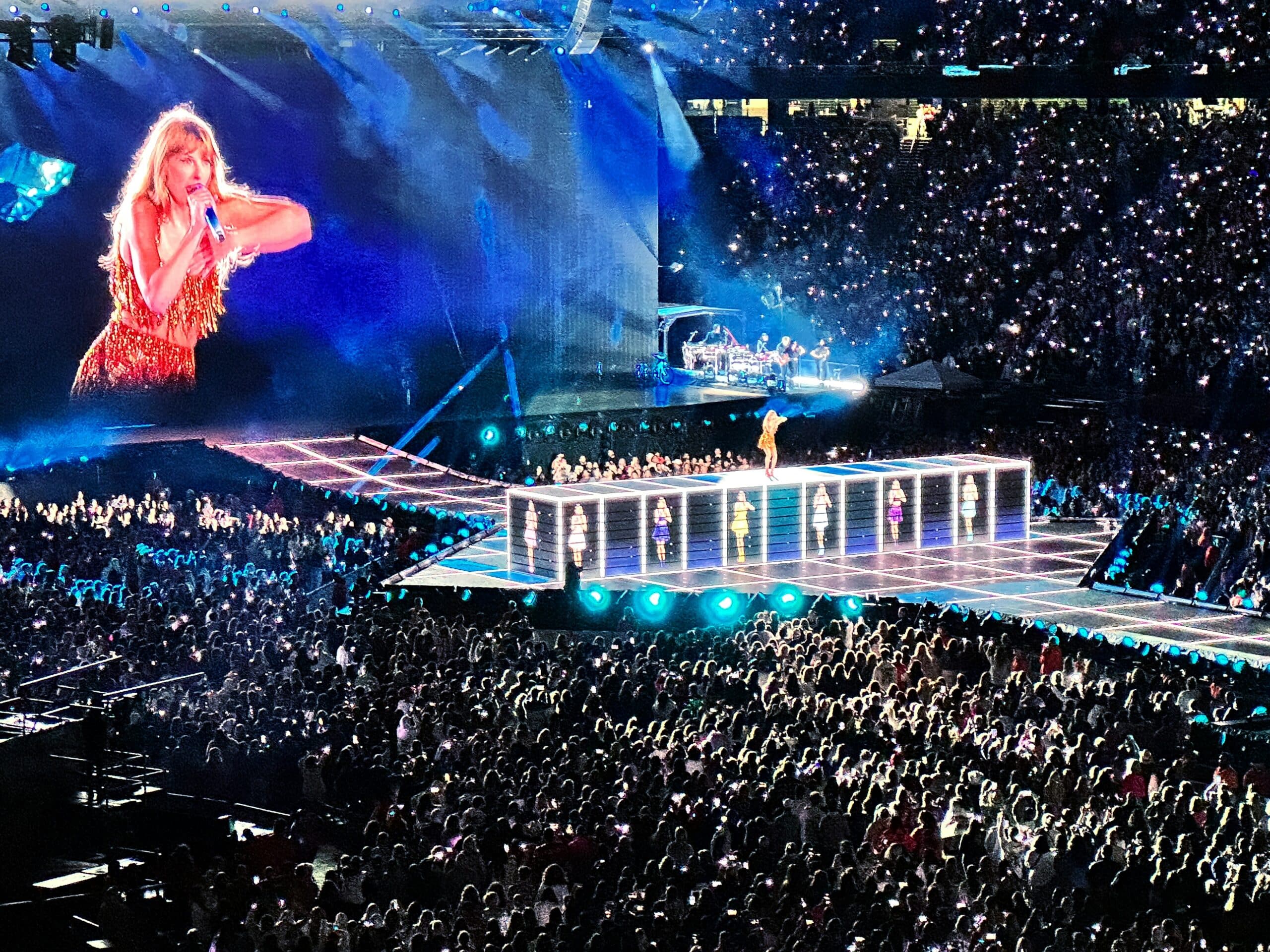 Taylor Swift performing on stage during her Eras Tour in a packed stadium, symbolizing the global reach and international tax implications of US performers working abroad.